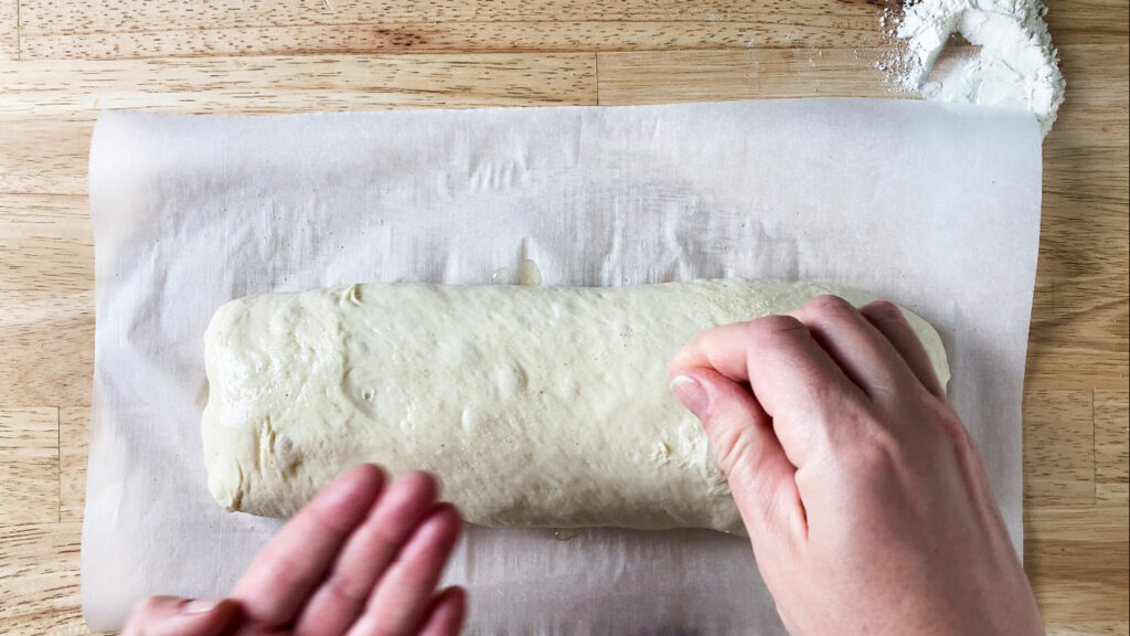 bread dough being covered with olive oil and salt