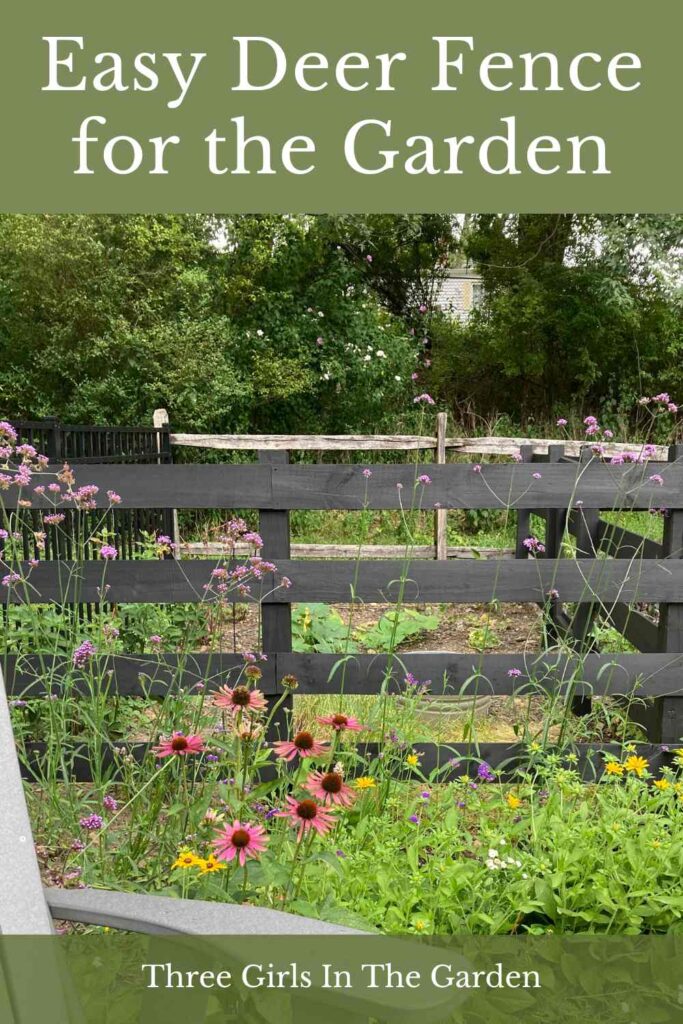 black rail fence with flower garden in front