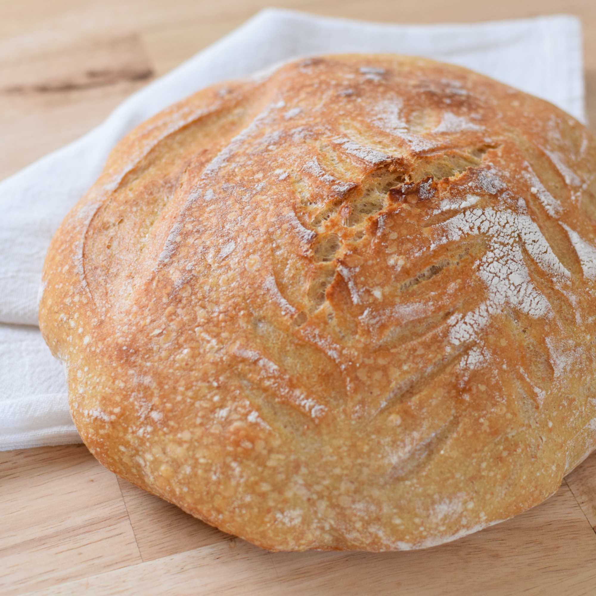 round sourdough bread on a tea towel