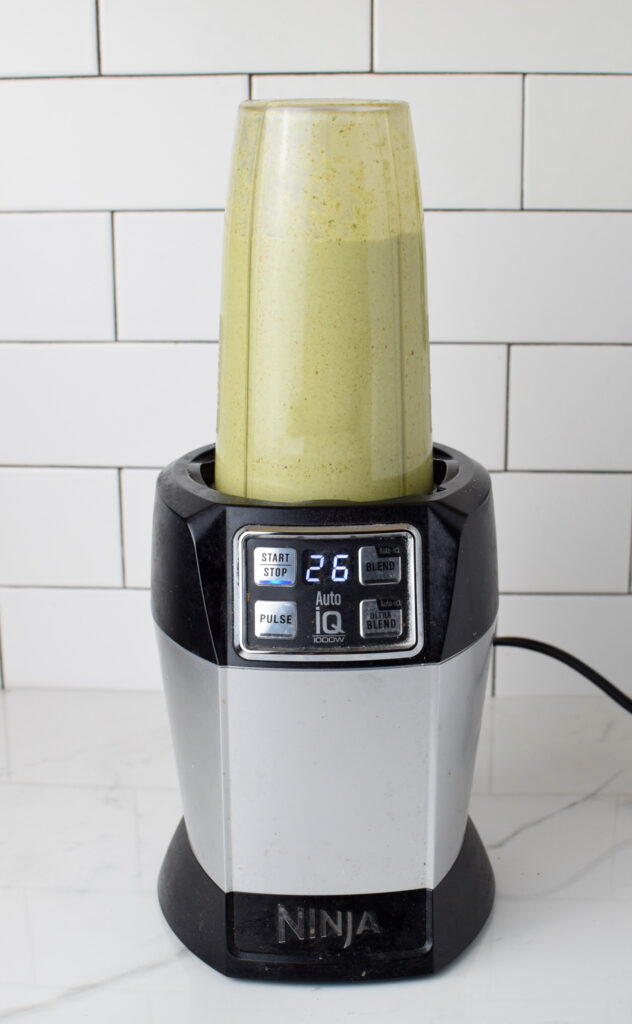 Ninja blender at 26 seconds with green batter being blended for banana pancakes for baby