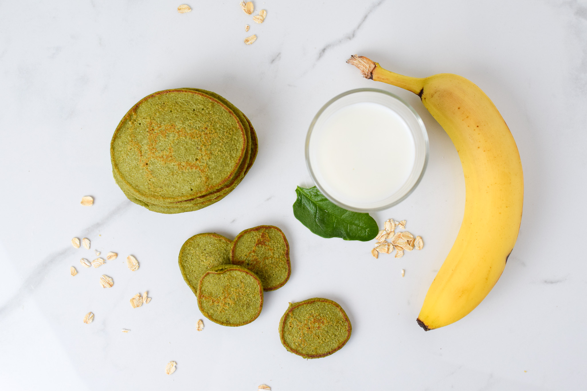 green pancakes stacked with banana, milk, oats and spinach