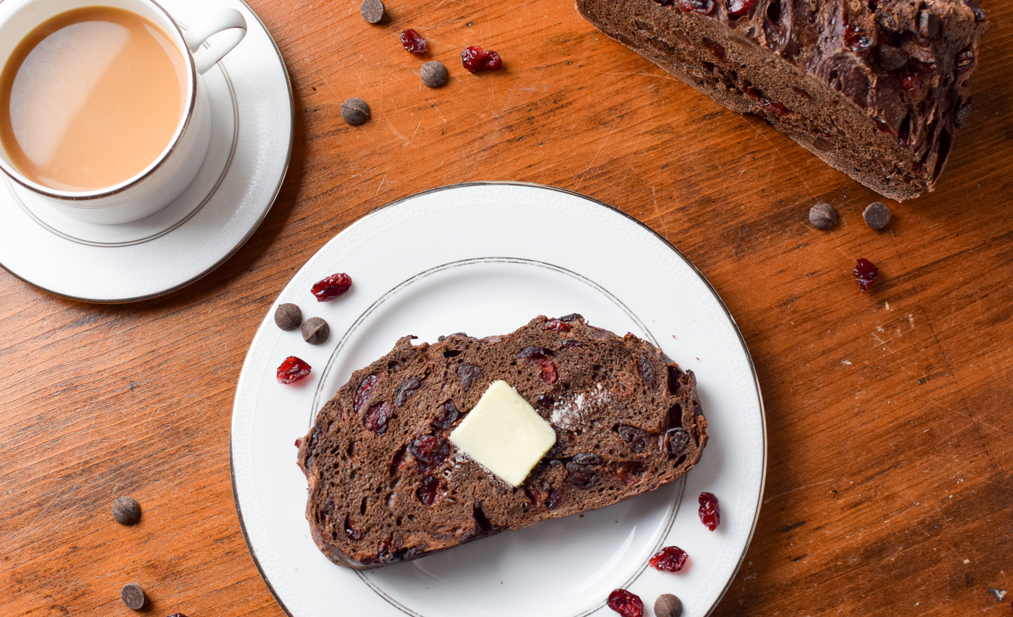 sliced chocolate bread with butter on a plate with coffee