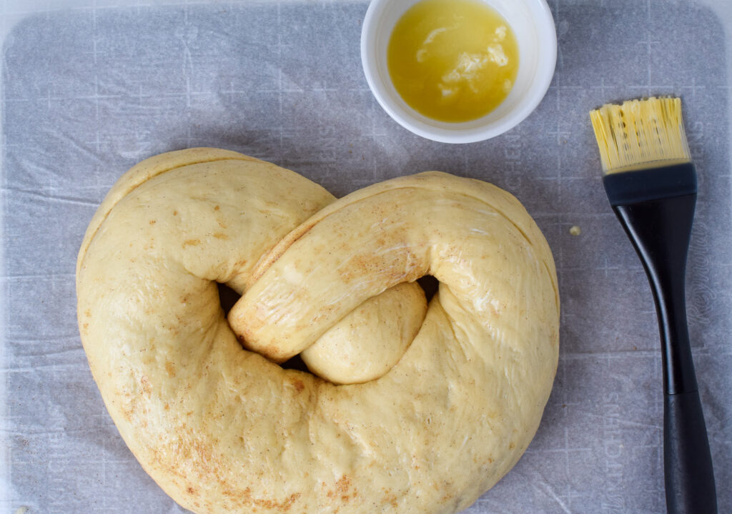 New Year's Pretzel dough being brushed with butter