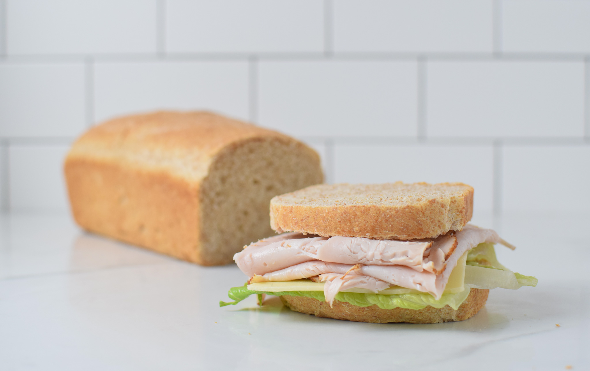 whole wheat sandwich bread on a counter with a sandwich