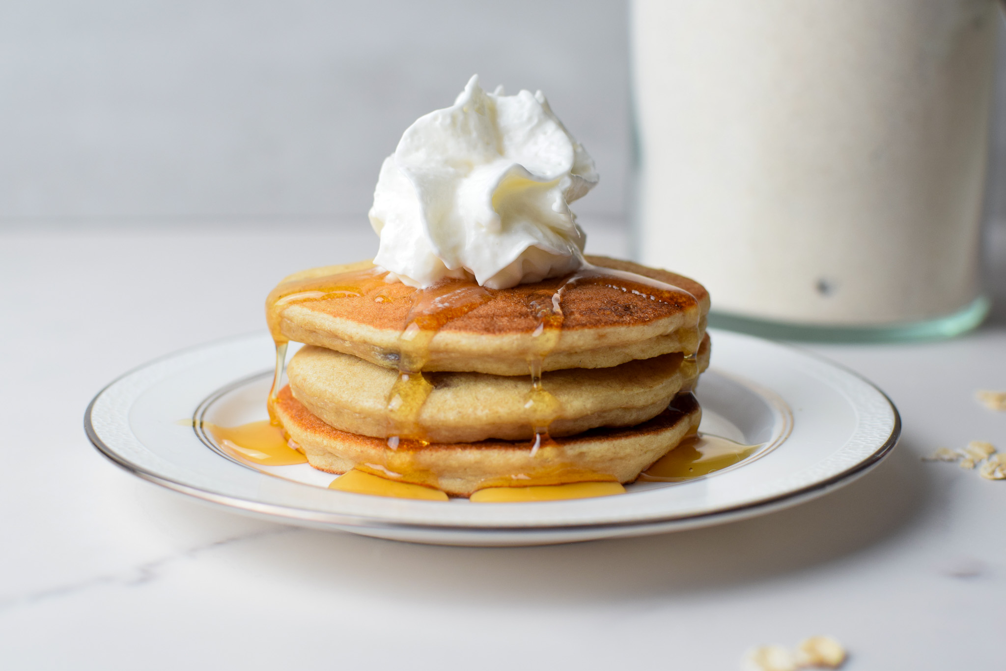 3 pancakes stacked with whipped cream and dry pancake mix in a glass jar